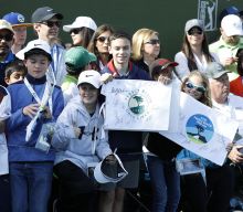 Kids holding signs to cheer on players at AT&T Pebble Beach Pro-Am