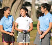 Three young women laughing on the golf course